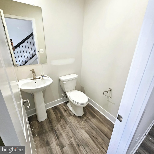 bathroom with wood-type flooring and toilet