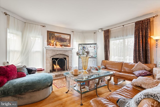 living room with hardwood / wood-style flooring and a brick fireplace