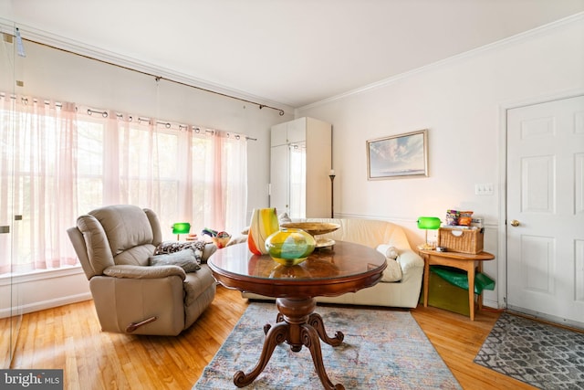 living area with light wood-type flooring and ornamental molding