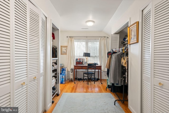 office with light hardwood / wood-style flooring and vaulted ceiling