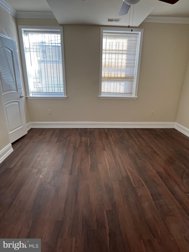 empty room with ceiling fan, dark hardwood / wood-style floors, and ornamental molding