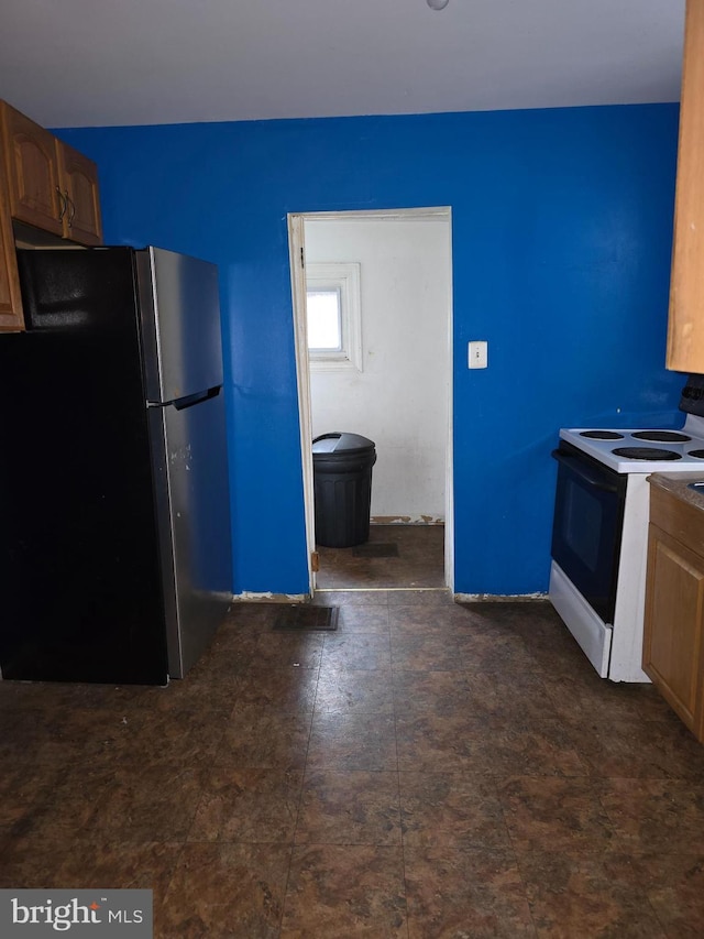 kitchen featuring stainless steel fridge and white electric range