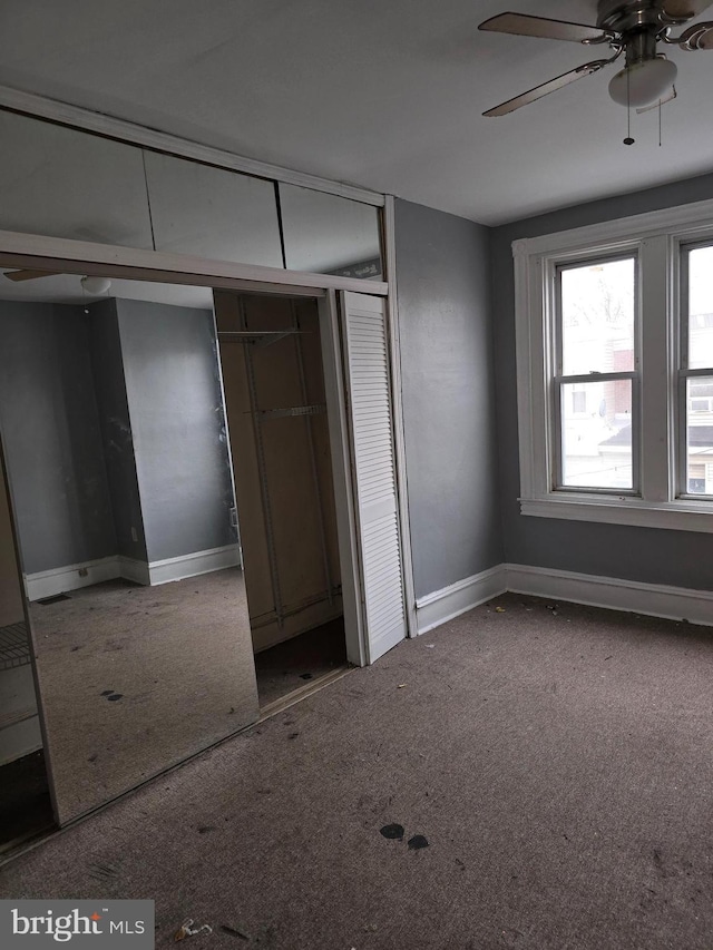 unfurnished bedroom featuring carpet floors, a closet, and ceiling fan