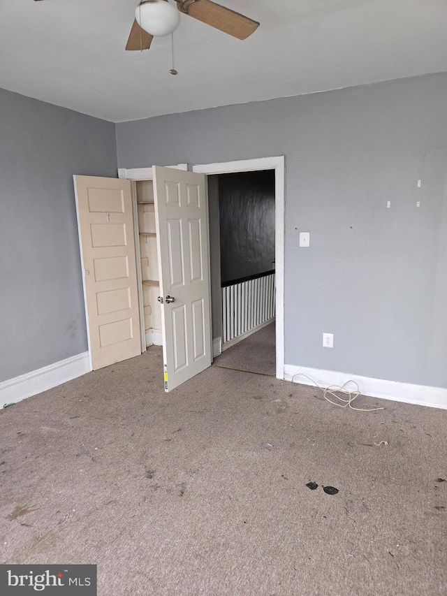 unfurnished room featuring ceiling fan and carpet