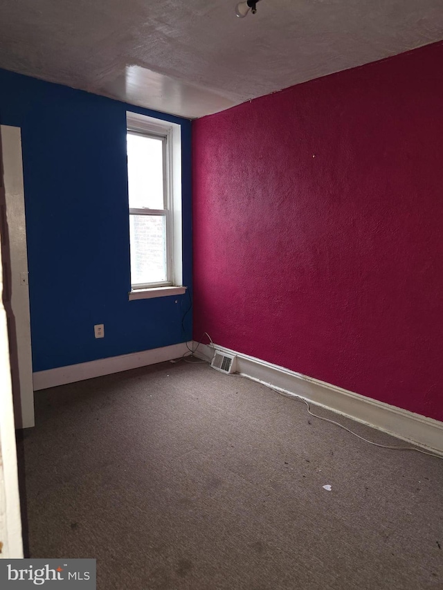 carpeted empty room featuring a textured ceiling