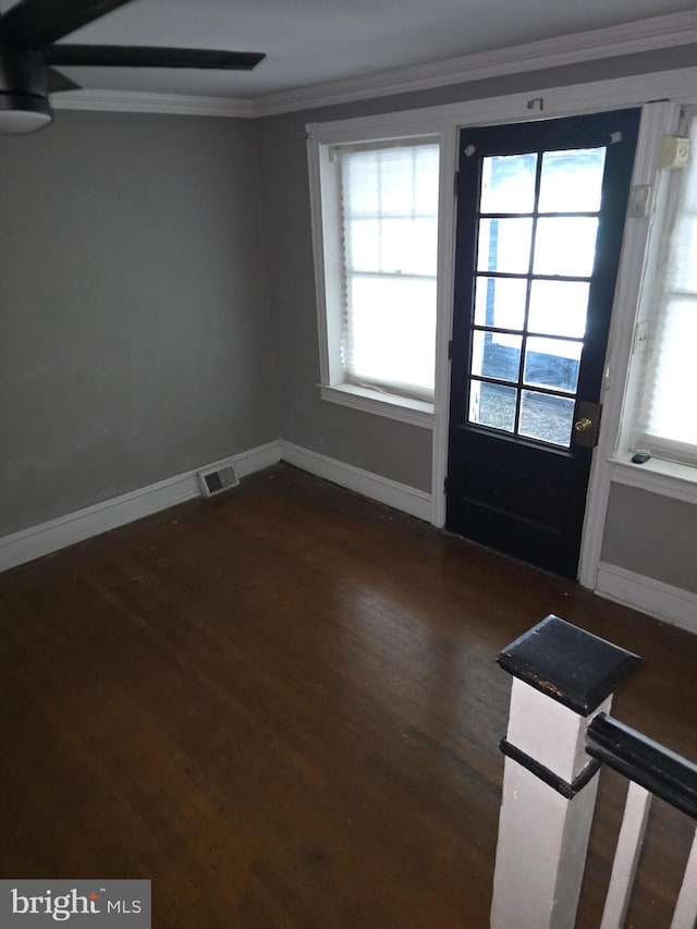 doorway to outside with dark hardwood / wood-style flooring, ornamental molding, and a wealth of natural light