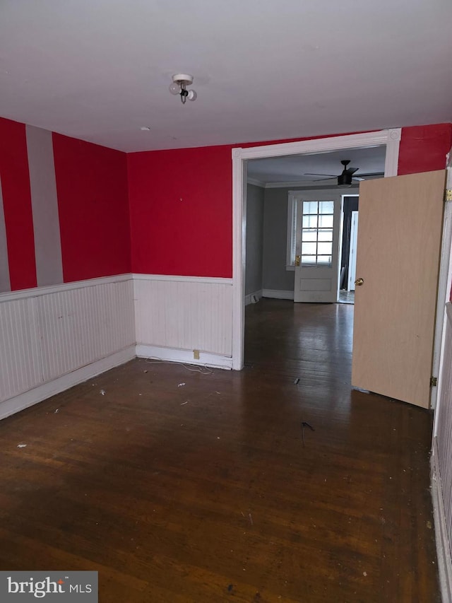 empty room with ceiling fan and dark wood-type flooring