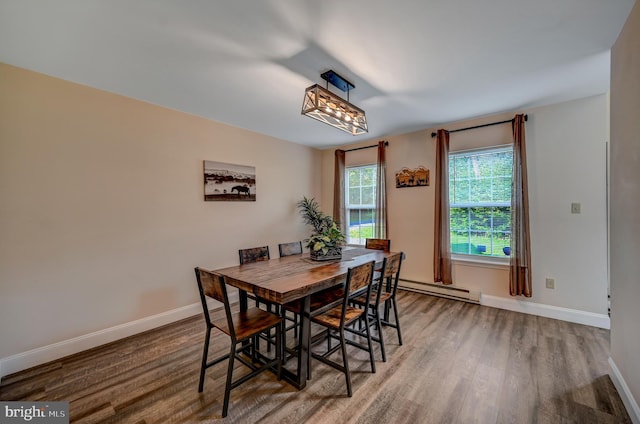 dining area featuring wood-type flooring and a baseboard heating unit