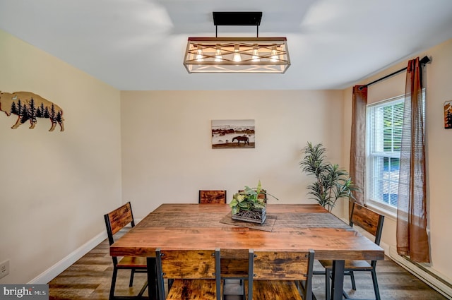 dining space with dark hardwood / wood-style floors and baseboard heating