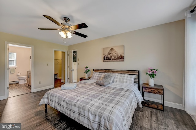 bedroom with ensuite bath, ceiling fan, dark hardwood / wood-style floors, and a walk in closet