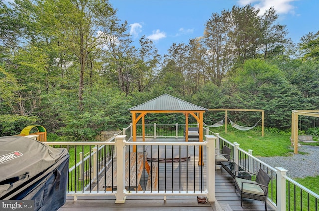 wooden terrace featuring a gazebo, grilling area, and a yard