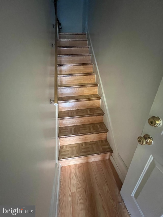 staircase with hardwood / wood-style flooring