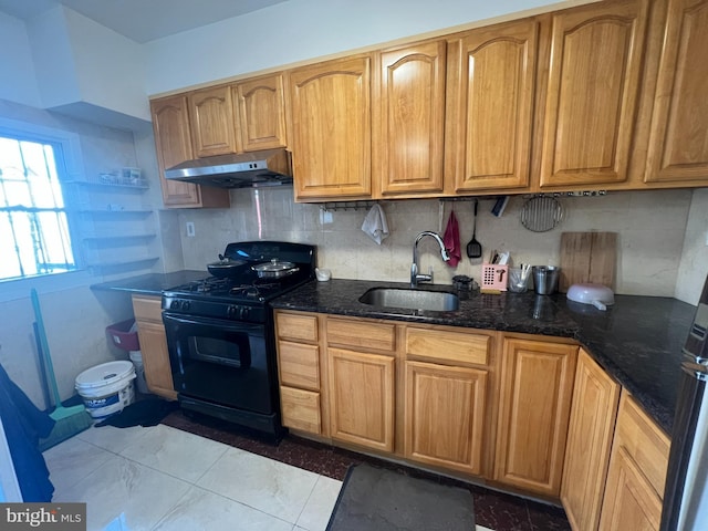 kitchen with tasteful backsplash, sink, black range with gas cooktop, and dark stone counters