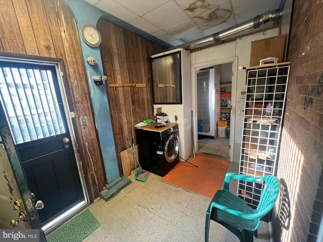 interior space with washing machine and clothes dryer and wood walls