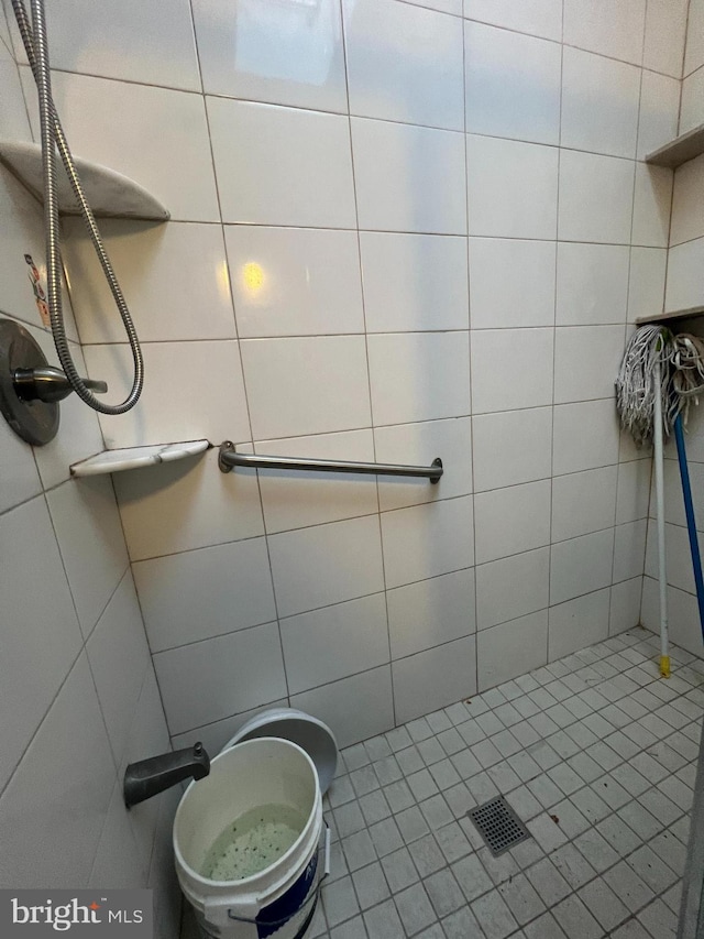 bathroom featuring tile patterned floors, tile walls, and walk in shower