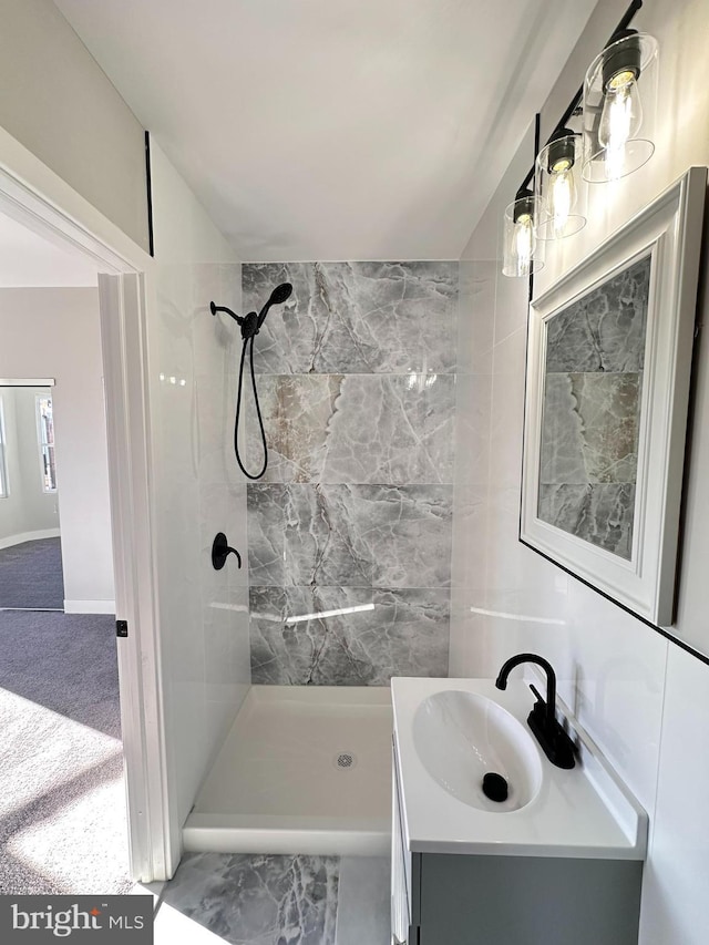 bathroom featuring a tile shower and vanity