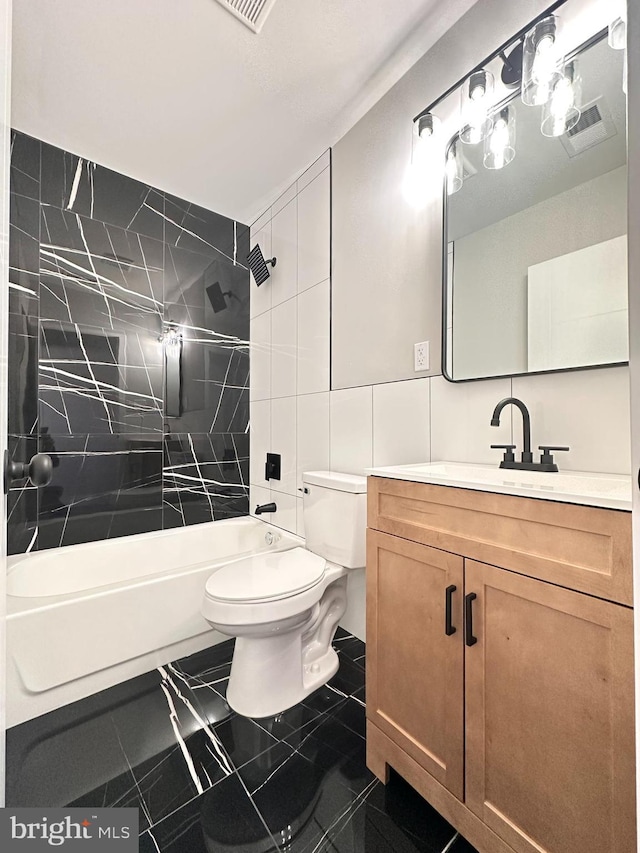 full bathroom featuring vanity, tile walls, tile patterned flooring, toilet, and tiled shower / bath