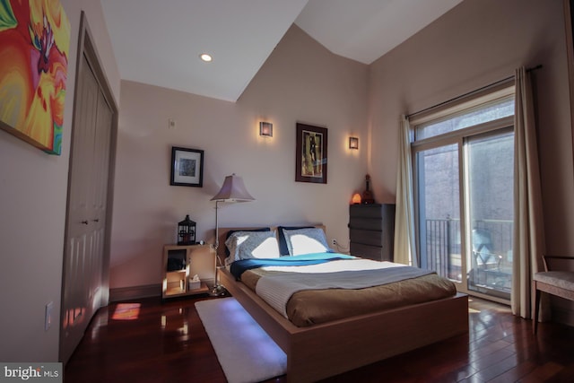 bedroom with access to outside, dark hardwood / wood-style flooring, a closet, and vaulted ceiling