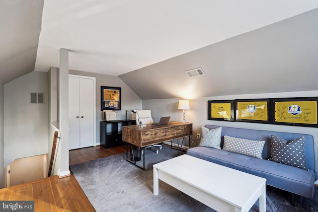 bedroom with dark hardwood / wood-style floors, vaulted ceiling, and a closet