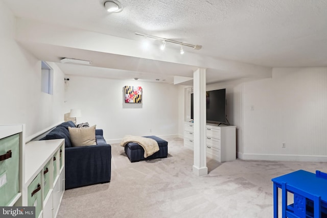 interior space with light colored carpet, a textured ceiling, and track lighting