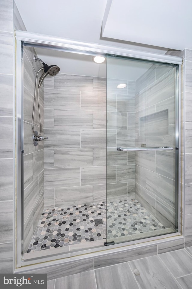 bathroom featuring a shower with door