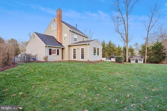 rear view of house featuring a yard and a storage shed