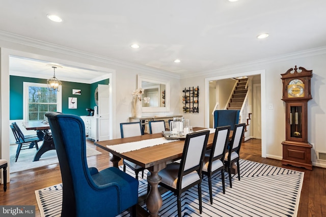 dining space featuring dark hardwood / wood-style flooring, a chandelier, and ornamental molding