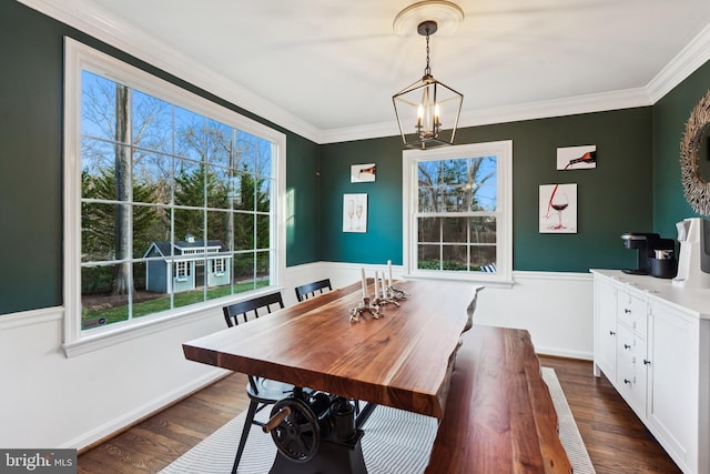 dining space featuring ornamental molding, dark wood-type flooring, and a notable chandelier