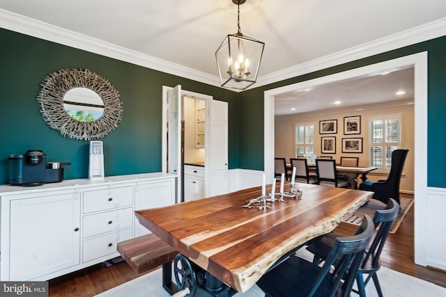 dining room with dark hardwood / wood-style flooring, crown molding, and a chandelier