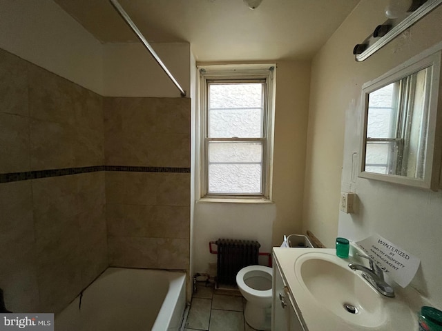 full bathroom featuring radiator heating unit, tiled shower / bath combo, tile patterned floors, toilet, and vanity