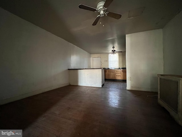 unfurnished living room with ceiling fan and dark wood-type flooring