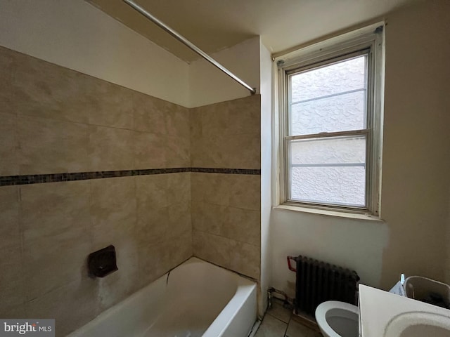 bathroom with tile patterned floors, radiator, tiled shower / bath combo, and toilet