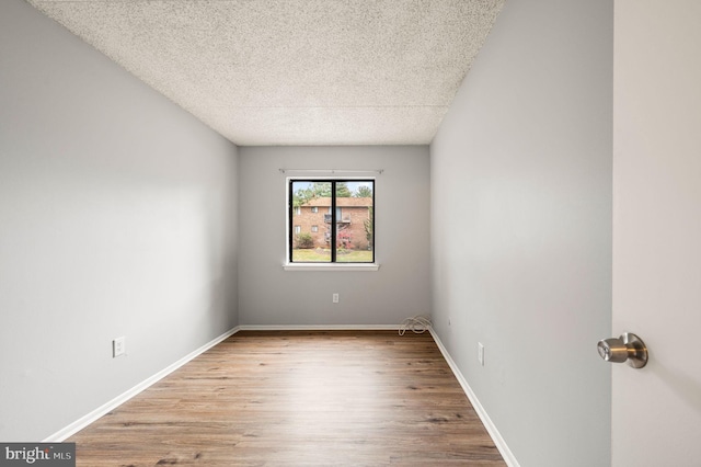 empty room with light hardwood / wood-style floors and a textured ceiling