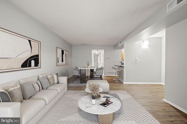 living room with light hardwood / wood-style floors and a textured ceiling