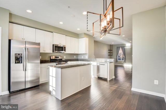 kitchen featuring kitchen peninsula, white cabinetry, dark hardwood / wood-style flooring, and stainless steel appliances