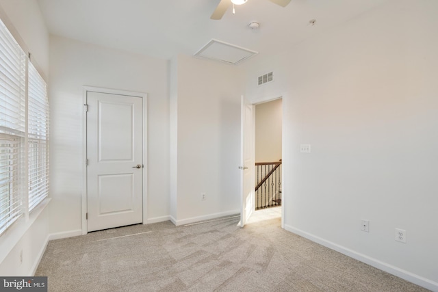 carpeted empty room with ceiling fan and a healthy amount of sunlight