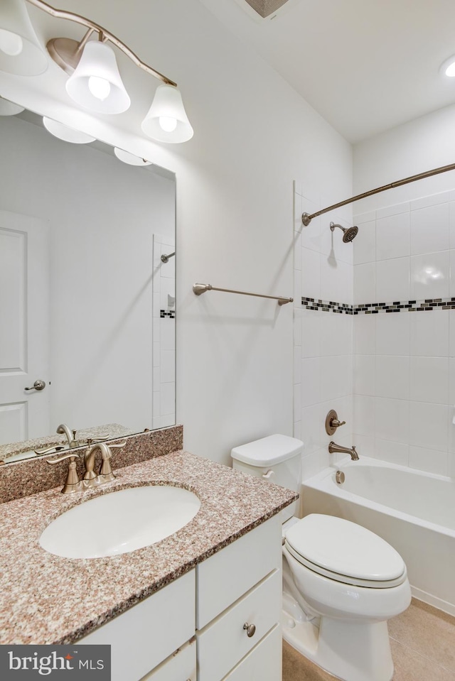 full bathroom with tile patterned floors, vanity, tiled shower / bath combo, and toilet