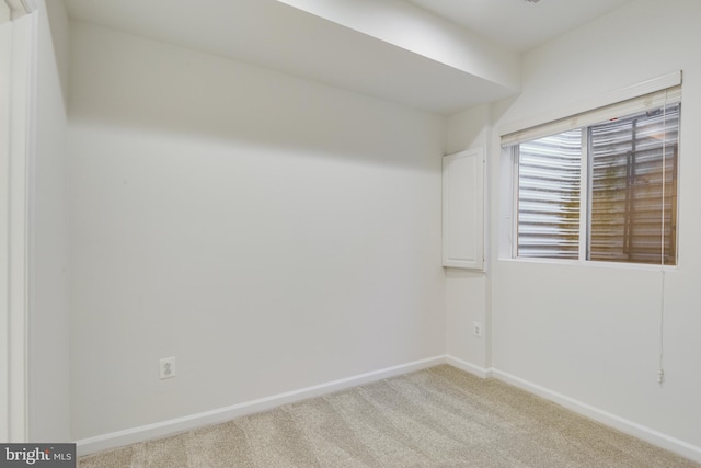 spare room featuring light colored carpet