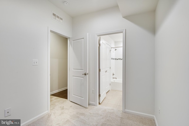 hallway with light colored carpet