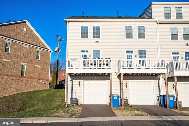 back of house with a lawn, central AC, and a garage