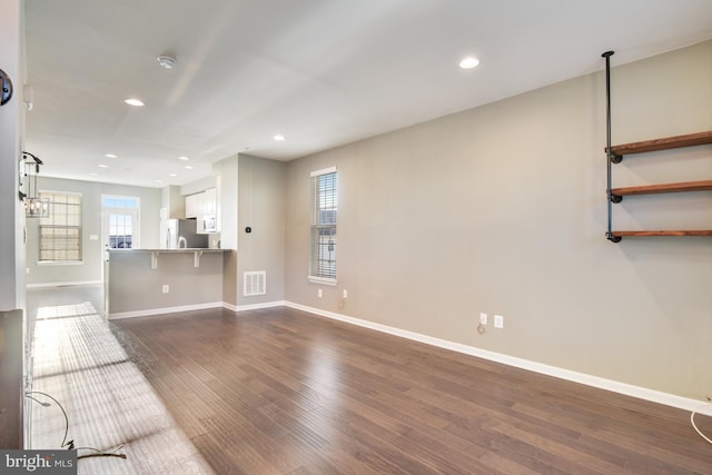 unfurnished living room with dark hardwood / wood-style flooring