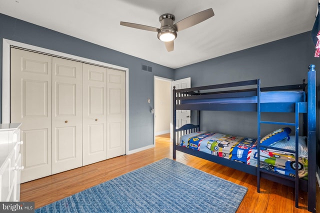 bedroom with ceiling fan, wood-type flooring, and a closet