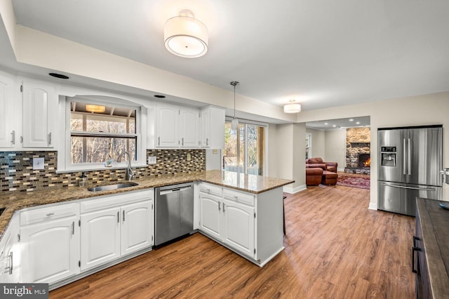 kitchen featuring kitchen peninsula, white cabinetry, and stainless steel appliances