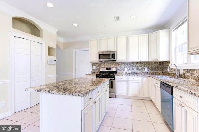 6614 Quander Rd, Alexandria, VA 22307 - kitchen with light stone countertops, appliances with stainless steel finishes, ornamental molding, sink, and a center island