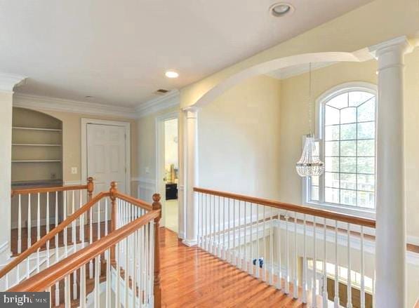 6614 Quander Rd, Alexandria, VA 22307 - hallway with built in features, wood-type flooring, an inviting chandelier, and ornamental molding