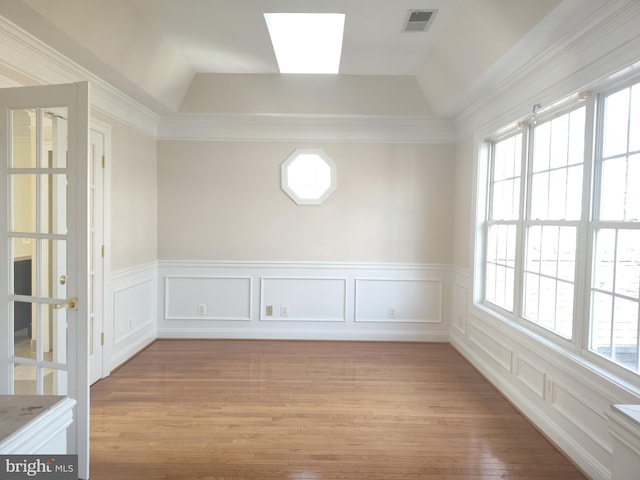 6614 Quander Rd, Alexandria, VA 22307 - unfurnished room featuring crown molding, lofted ceiling with skylight, light hardwood / wood-style flooring, and a healthy amount of sunlight