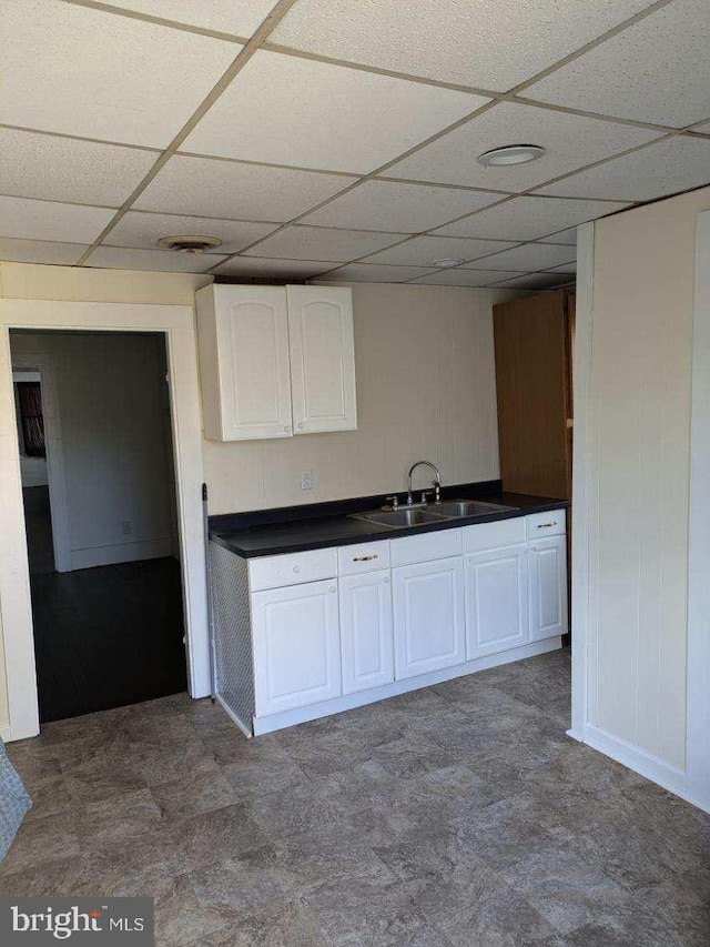 kitchen featuring white cabinetry, sink, and a drop ceiling