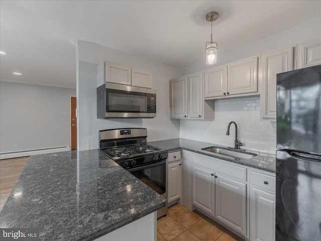 kitchen with sink, hanging light fixtures, light wood-type flooring, baseboard heating, and stainless steel appliances