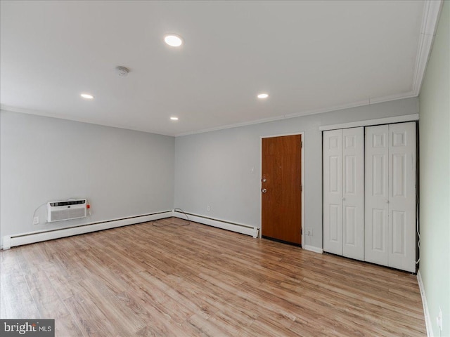 unfurnished bedroom with a baseboard heating unit, crown molding, a wall mounted AC, and light hardwood / wood-style flooring