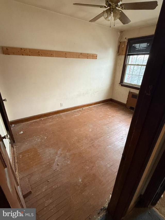 spare room featuring radiator heating unit and ceiling fan